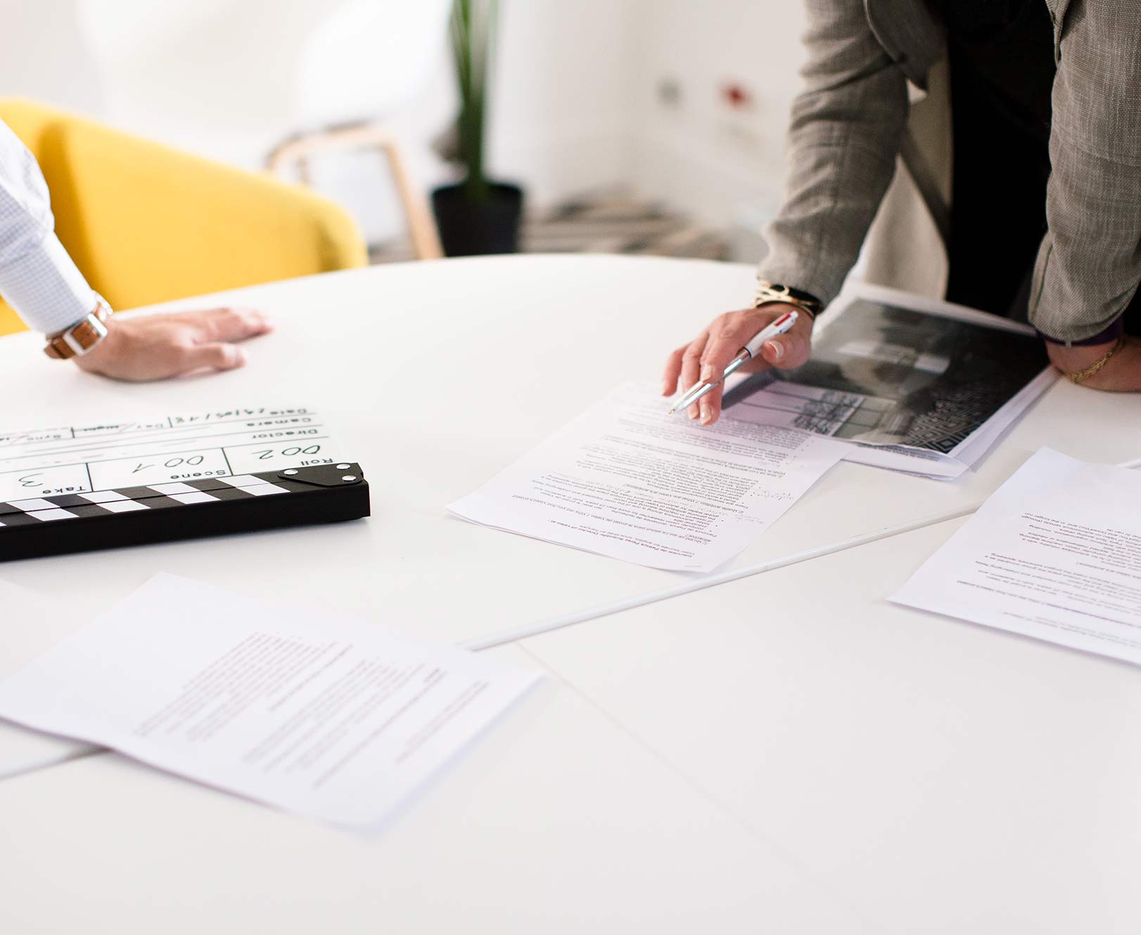 Réunion de préproduction vidéo d'entreprise : script, storyboard et clap de tournage sur une table — agence Couloir 3